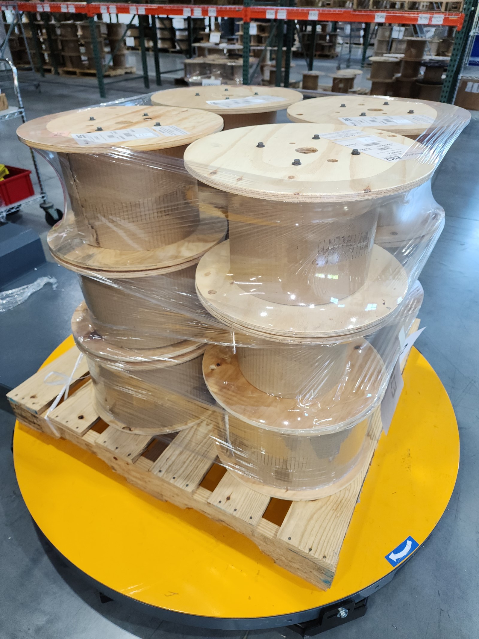 An organized stack of wire spools, securely wrapped in protective plastic by Handle It stretch wrapping equipment.