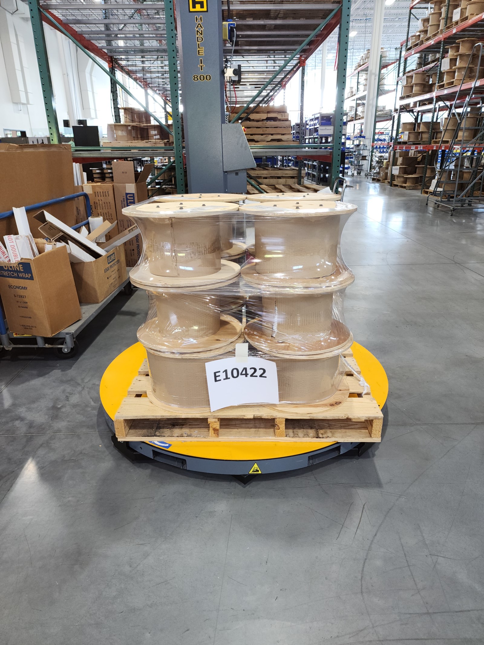 An pallet of wire spools, securely stretch wrapped by the Handle It 800 semi-automatic pallet wrapper.