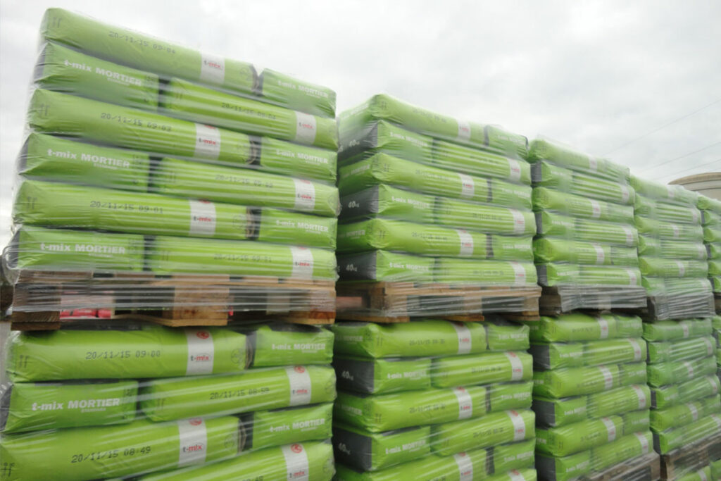 A pallet of stacked bags secured with a clear plastic stretch hood, illustrating 5-sided, weatherproof load protection for transit and storage.